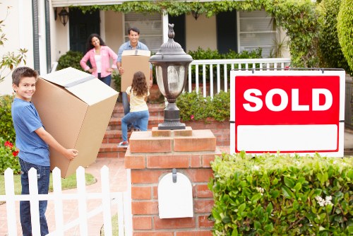 Professional movers carrying furniture from a Petts Wood property
